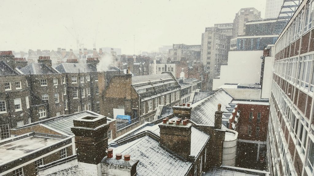 Row of terrace house rooftops covered in snow