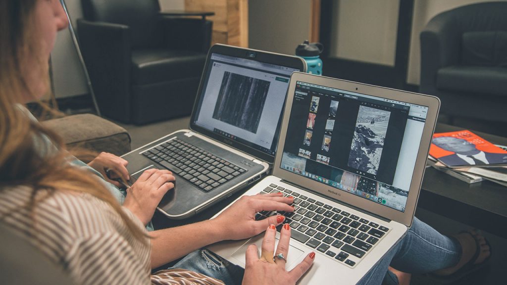 Woman types on silver laptop