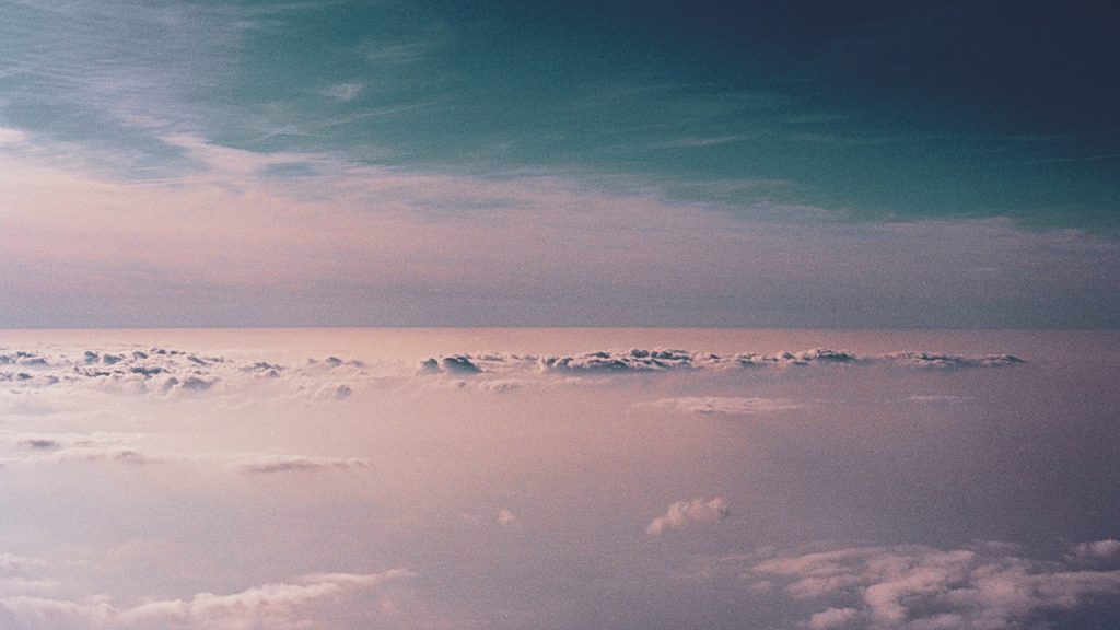 Pink tinged sky with a layer of light cloud below a layer of darker blue clouds