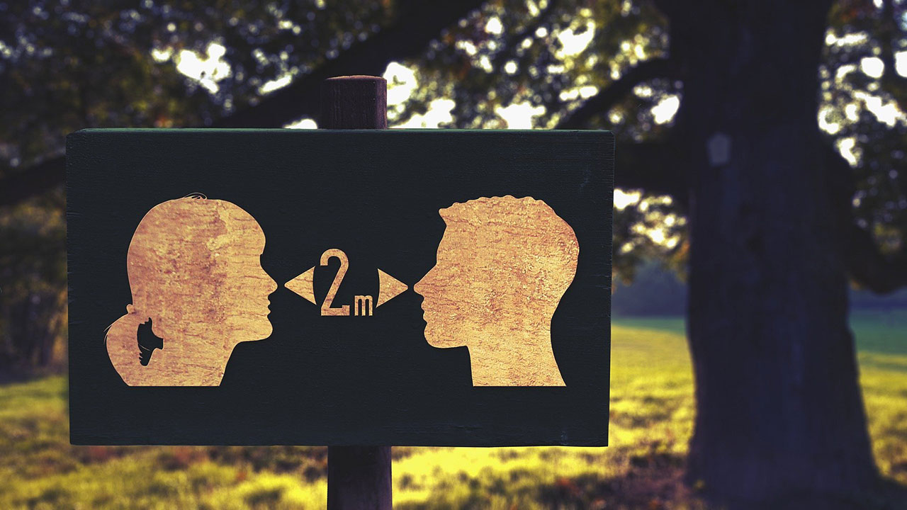 Public sign showing two silhouetted people and encouraging a two meter distance between them
