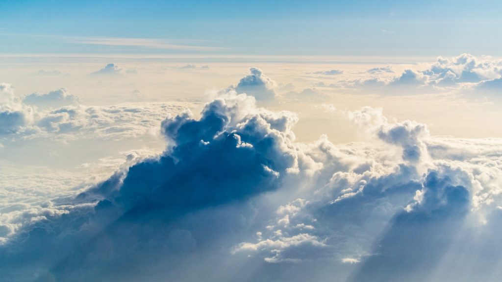 Large, dramatic cloud formations in the sky, casting a long dark shadow