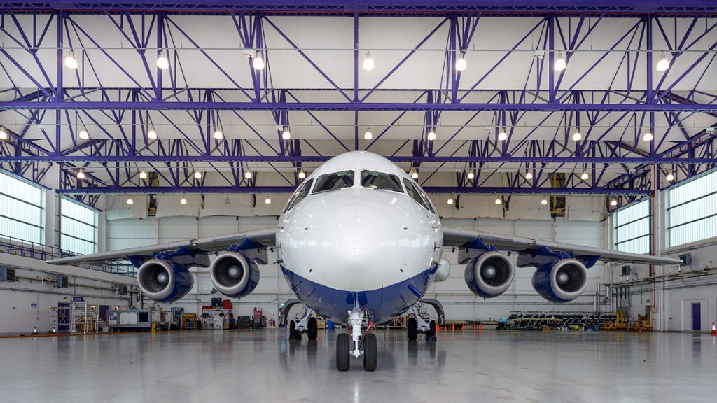 White and blue aircraft inside a large hangar