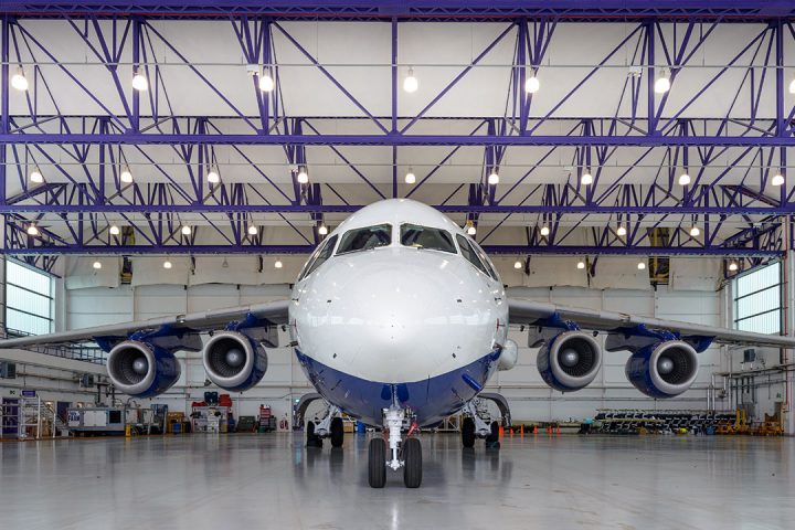 White and blue aircraft inside a large hangar