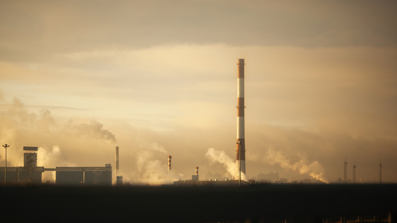 Smokestacks rise from a factory building on the horizon