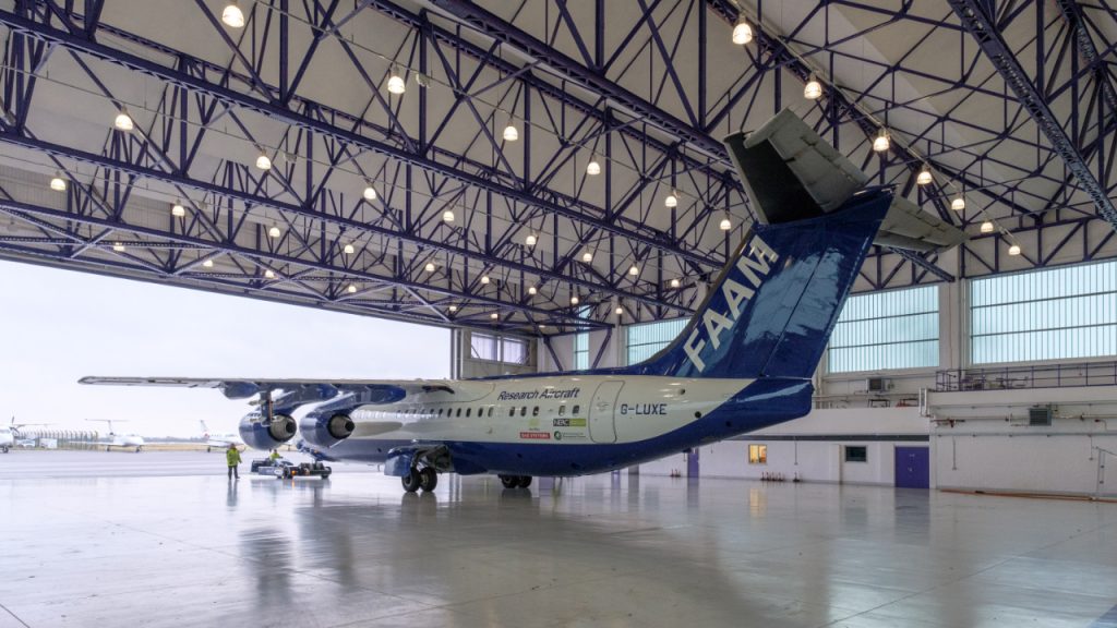 FAAM atmospheric research aircraft in an empty hangar, facing out towards open doors