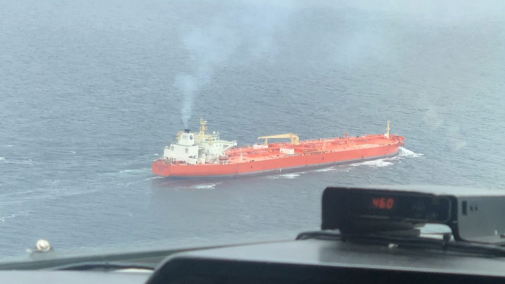 Red cargo ship emits exhaust plume and is seen from above from the FAAM aircraft