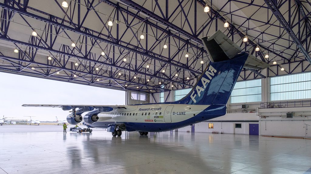 Large white and blue aircraft in open hangar