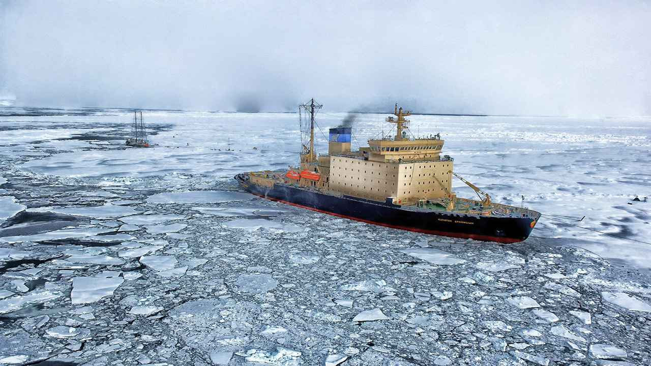 Large ship breaks through cracked ice in the Arctic sea