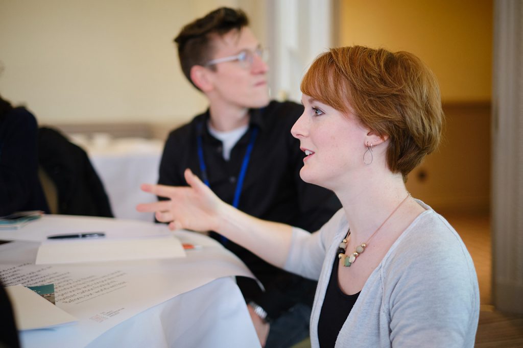 Young woman sits at table during conference event