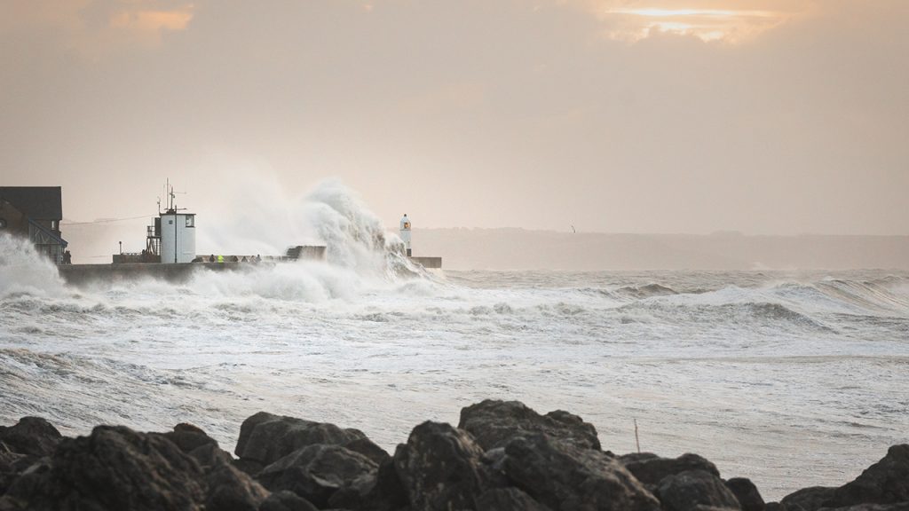 White waves crash against coastal peninsula