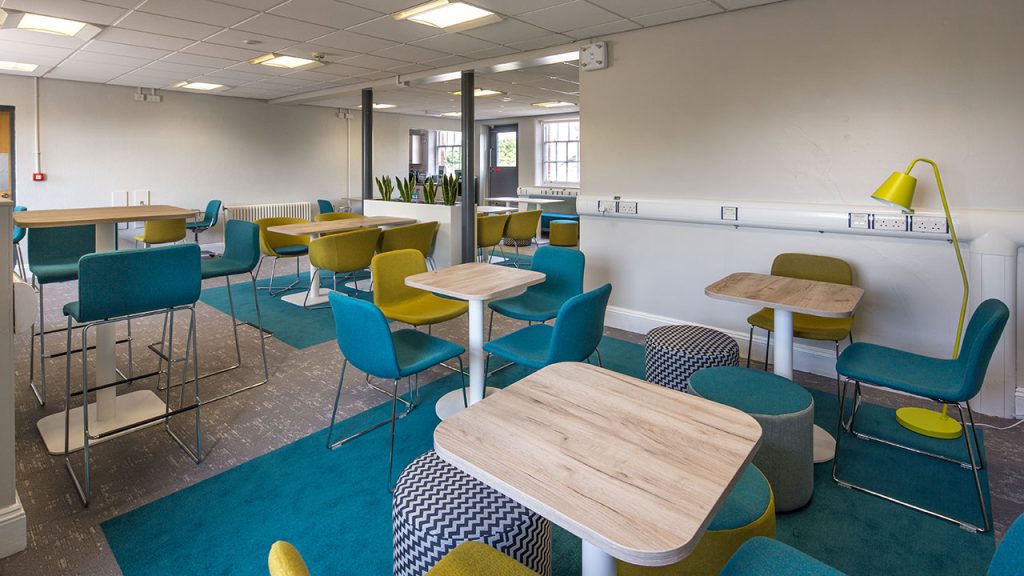 Social space with dozens of chairs around square tables