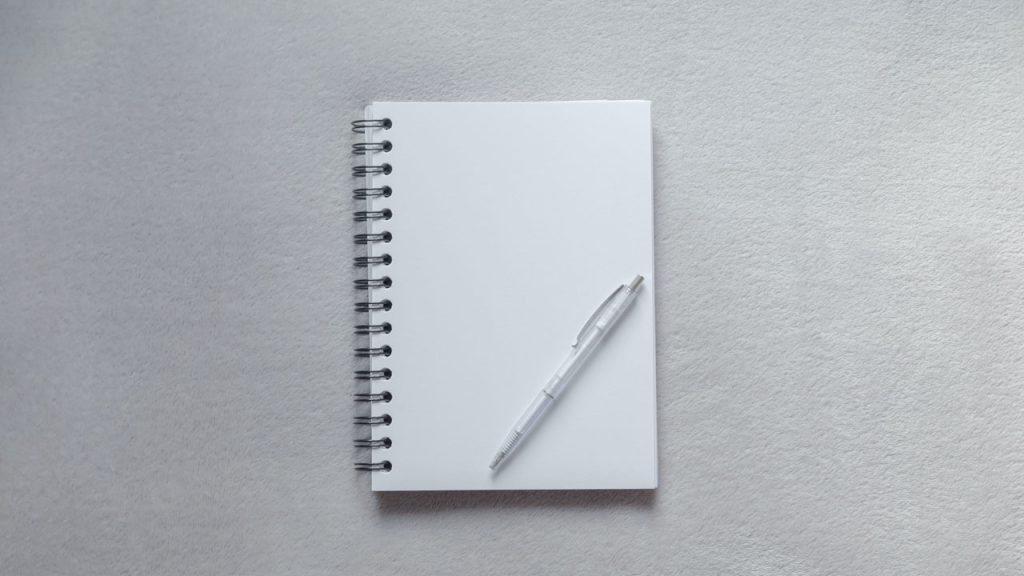Open notepad with pen lying on top