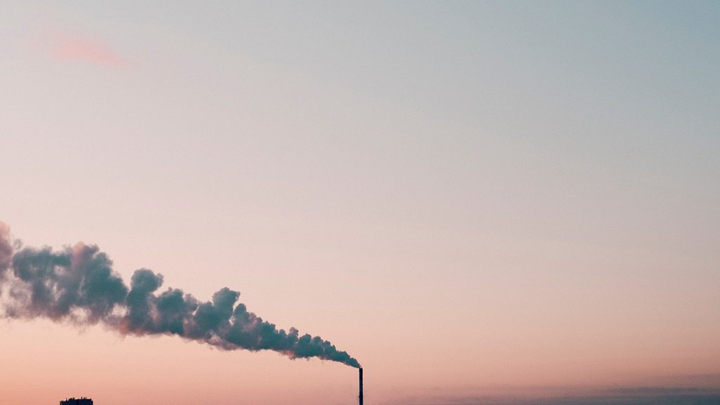 pastel pink and blue sky with a chimney emitting a stream of cloud over to the left