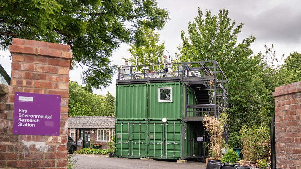 Green shipping containers with scientific instruments on rooftop