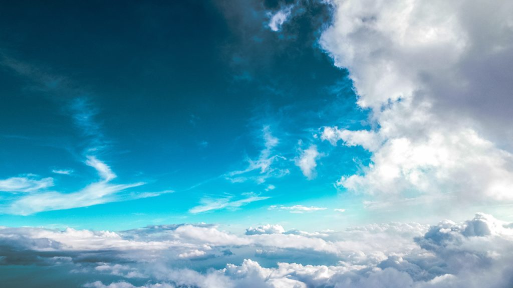 Above a layer of clouds in a turquoise and blue sky