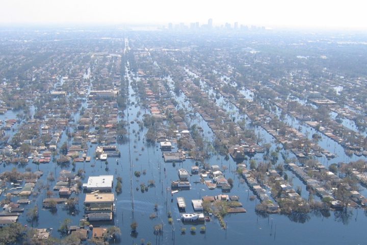 Aerial view of a flooded suburb, rows of houses are submerged in blue water