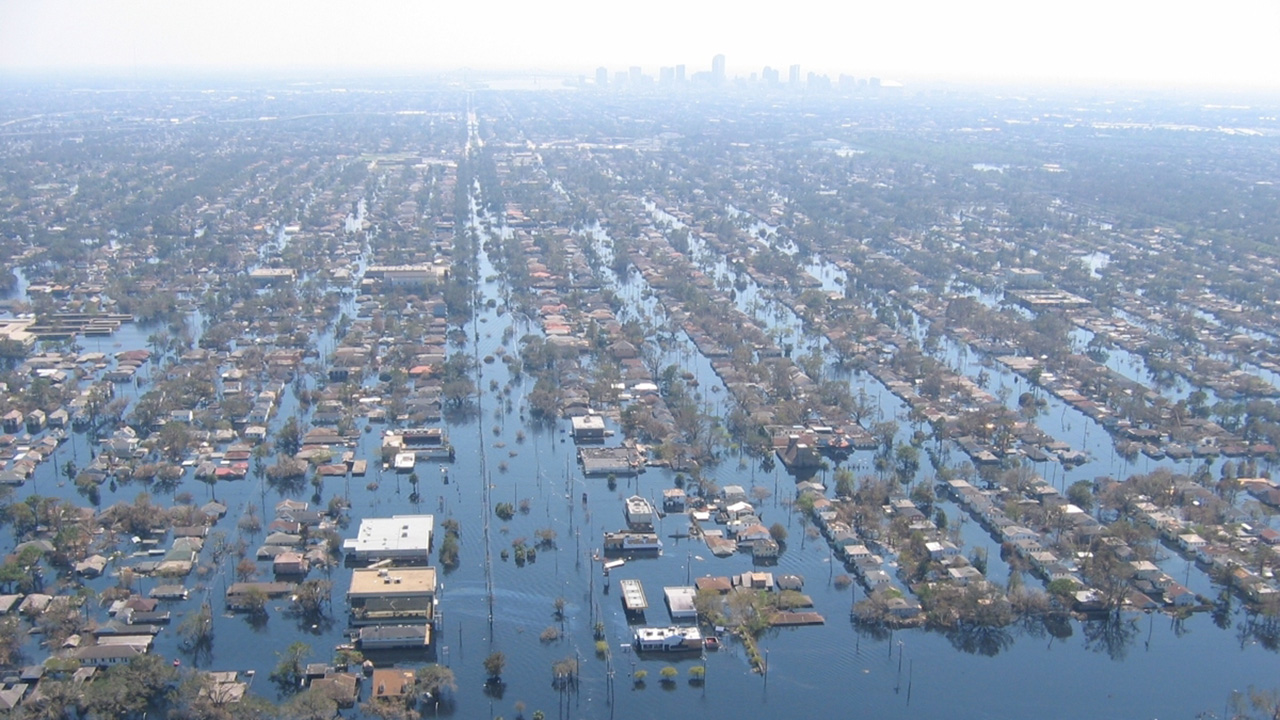 Aerial view of a flooded suburb, rows of houses are submerged in blue water