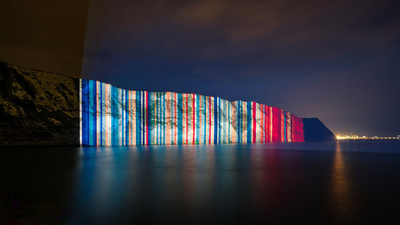 Warming Stripes projected onto the White Cliffs of Dover at night.