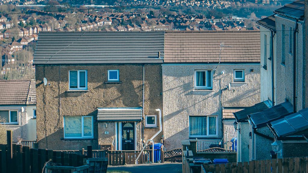Grey and brown pebbledash houses in Sheffield, with rows of houses in the background.