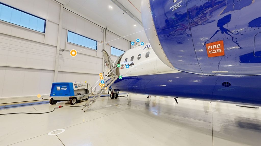 A blue and white aircraft with the door open near the cockpit.