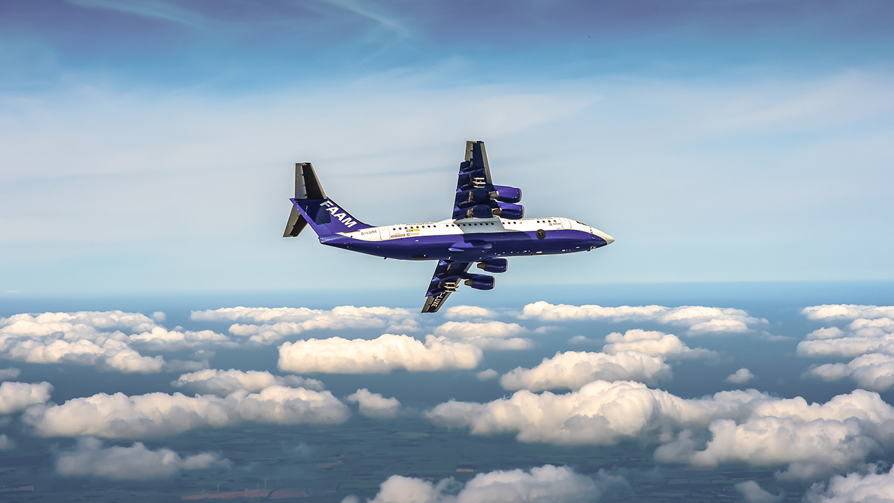 blue and white aircraft flying above small fluffy white clouds