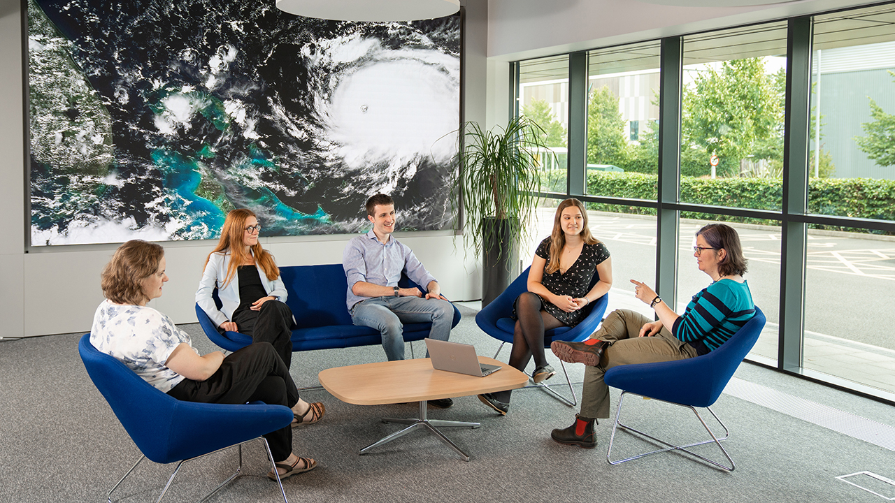 group of 5 people sat in blue chairs