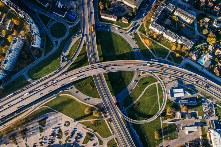Aerial view of busy roads in an urban area, with some green space.