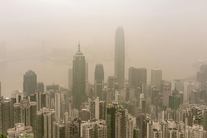 skyscraper buildings rising up into thick polluted air and cloud