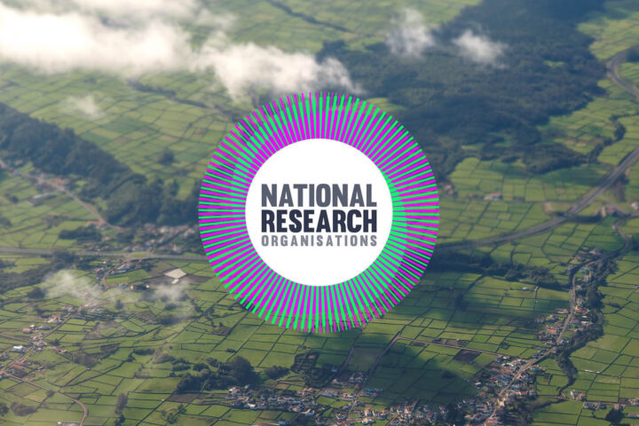 Aerial view of green fields and white clouds, with a purple and green logo that reads National Research Organisations.