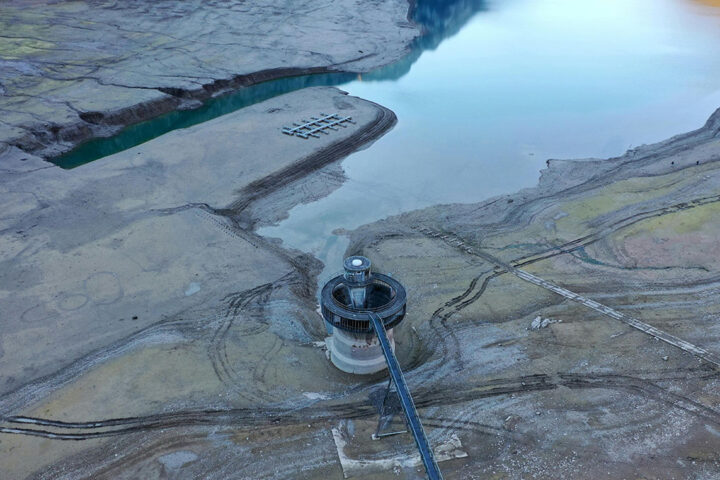 Dry reservoir, with exposed soil and reservoir building