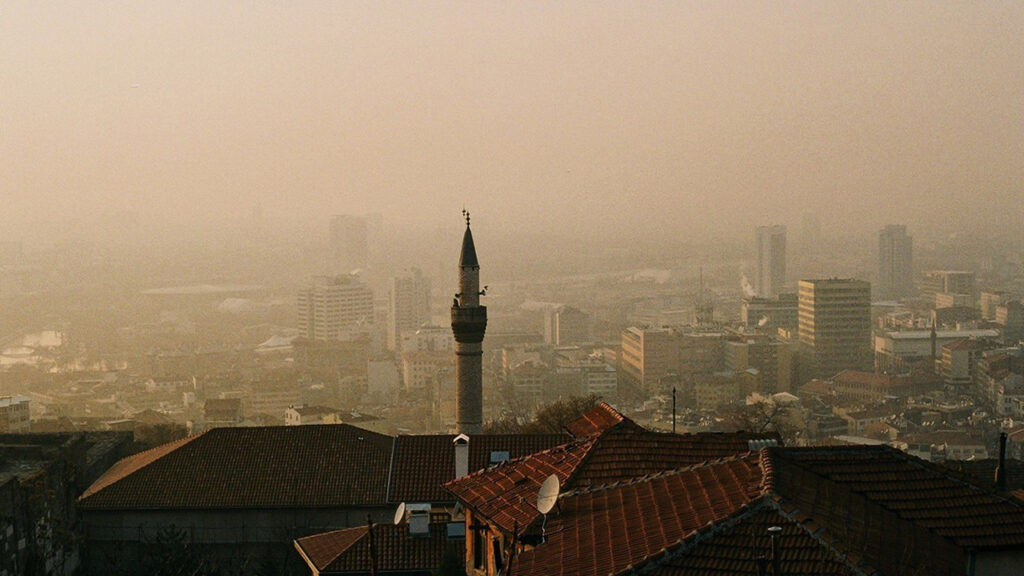 Dusty skyline in European city, with a pale brown and orange haze sitting above rooftops.