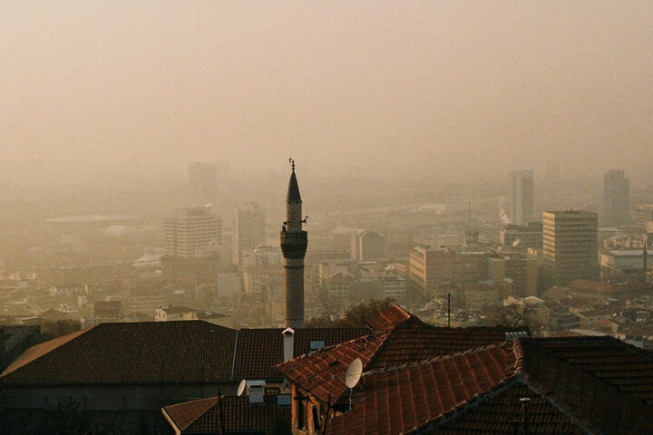 Dusty skyline in European city, with a pale brown and orange haze sitting above rooftops.