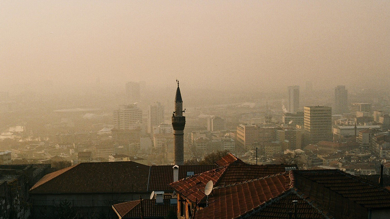Dusty skyline in European city, with a pale brown and orange haze sitting above rooftops.